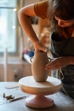 Busy Artist Female Moulding Potter Vase In Studio. Woman Owner Of Craft Tableware Shop Creating New Pottery For Retail Store. Art Classes Hobby Occupation And Small Business Entrepreneurship Concept