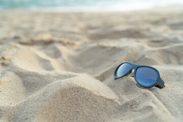 Fototapeta na wymiar Sunglasses on the beach for vacation concept or for summer background