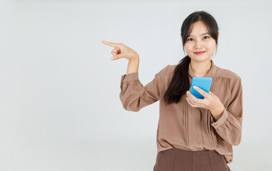 Gorgeous young Asian woman cheerfully pointing finger with smile to interesting copy space for...