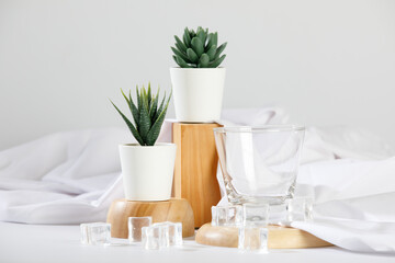 Gorgeous flower pot and empty drink glass on wooden tray with ice and cloth decoration on deluxe dining table for modern luxury spa and health care clinic