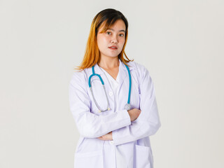 Portrait studio shot of Asian young successful professional confident dyed hair female doctor in lab coat hanging stethoscope around neck standing crossed arms look at camera on white background