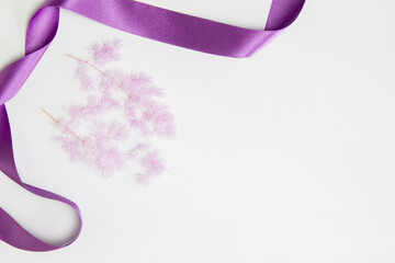 Purple flowers with purple ribbon over the white background. 