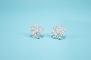 Tribal silver earrings on pastel blue background