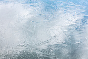 shiny frosty ice surface with different patterns and cracks. closeup view.