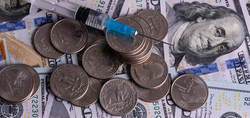 Disposable syringe and American currency on black background