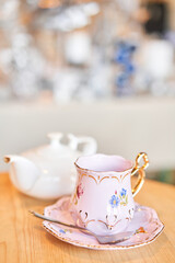 teapot and cup. A magnificent porcelain tea set with a fragrant tea. Green and black tea concept. Side view.