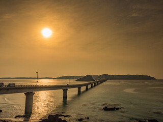 Fototapeta na wymiar 角島大橋と夕日。Tsunoshima Bridge and the setting sun.
