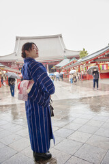 Fototapeta premium 浅草の浅草寺の前に立つ着物姿の日本人女性