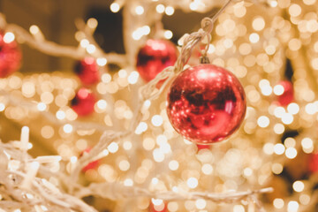 Blurred bokeh of Christmas light and red ball background.