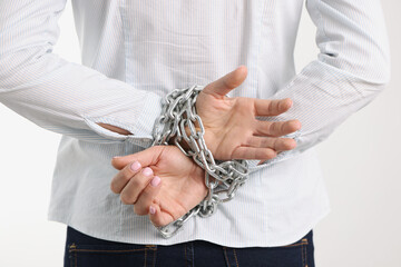 Woman hands are tied with chain behind backs