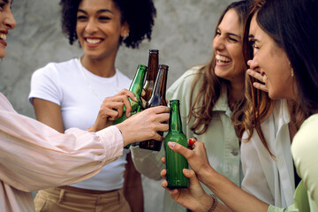Girlfriends toast beer bottles