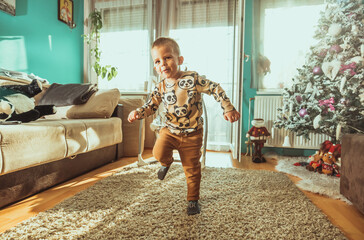 Little boy happily jumping on a home interior