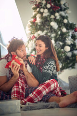 couple holding Christmas box.Woman giving Christmas present to her boyfriend