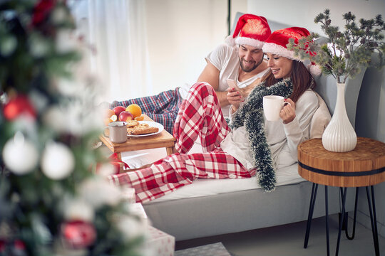 Christmas morning in the bed.Men and  woman at Christmas morning texing mesage