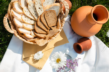 basket with bread sliced clay jug in nature