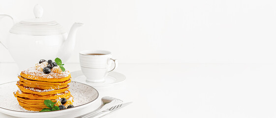 Heap of american pancakes or fritters on white table. Banner, copy space.