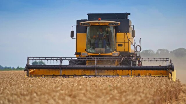 Huge combine harvester working on the agricultural field and gathering crops. Combiner ruling a big harvester machinery in wheat field.