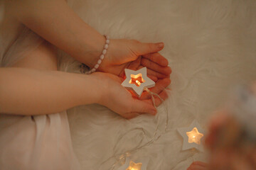 christmas atmosphere garland bokeh children reading a book asterisks light звезда в руках
a star in your hands