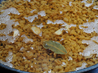 Hot melted pork fat, lard and pork rinds in a frying pan, closeup. Recipe of natural oil, for cooking