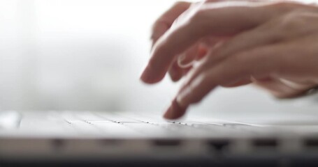 Female fingers are typing text on the laptop keyboard. Business woman works using a computer. Close-up. - Powered by Adobe