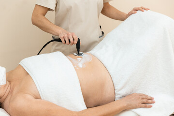 Woman receiving radiofrequency stimulation treatment for faster recovery like for inflammations, pelvic floor, scarring