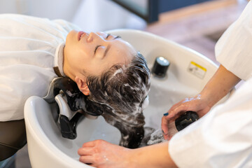 ヘアサロンでスチームトリートメントを受ける女性