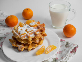 veccique waffles with a mug of milk and tangerines