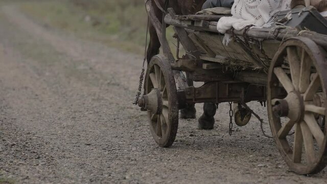 Ancient wooden horse cart moving by rural country road historical site. History film shot. 4K slow motion.