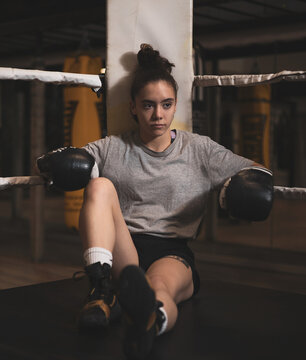 an underage girl leaning on a ring before boxing.