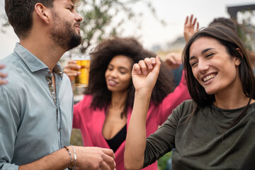 Group of friends having fun dancing together on the rooftop