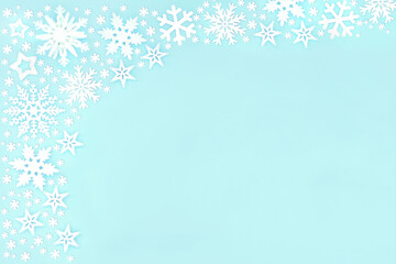 Christmas snowflake and star background border composition on on blue background. Festive layout for the holiday season. Flat lay top view, copy space.