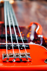 orange electric bass guitar on wood background with copy space
