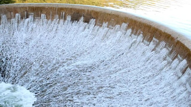The circle wall of dam with overflowing water
