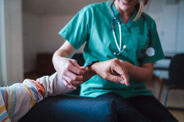 Smartwatch for health care. A woman from the medical health system wears a smartwatch for remote...