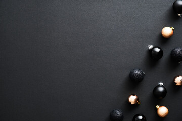 Frame border made of Christmas baubles decoration on black background. Flat lay, top view, copy...