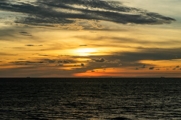 Dramatic clouds and sunset sky over the sea with golden clouds in Port Dickson, Malaysia.