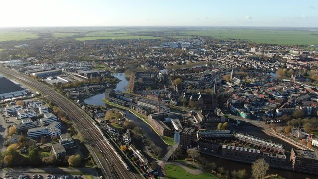 4k aerial video of historic village Woerden in the netherlands with trains driving by