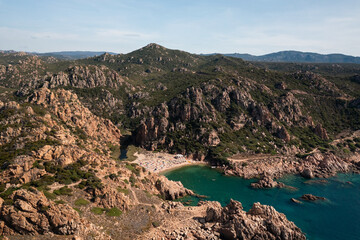 Fototapeta premium Aerial view of a stone shoreline and turquoise sea water illuminated by the sun.