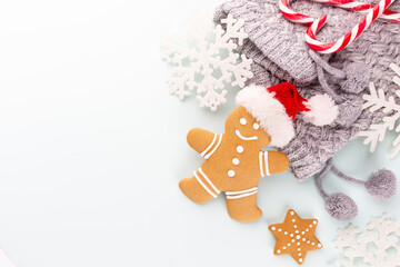 Gingerbread man, cookies and Christmas decor on pastel background.