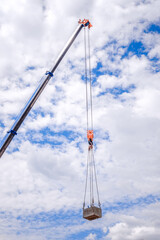 Crane with a cargo with a blue sky background