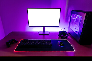 Desk with gaming setup. Display with isolated screen for mockup. Gaming PC, headset, keyboard,...
