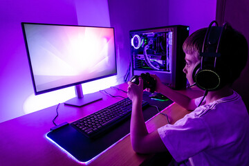 Gamer play game on gaming PC with joypad. Modern gaming setup with water cooling case, joypad, mouse, headset. © Stanisic Vladimir