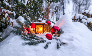 Weihnachtliche Deko mit Laterne im verschneiten Garten