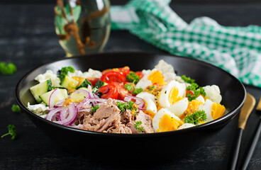 Healthy food. Tuna fish salad with eggs, lettuce, cherry tomatoes, cucumber and red onions.  French cuisine.