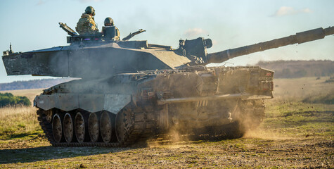 close up motion shot of a British Army Challenger 2 FV4034 Main Battle Tank kicking up dust with...