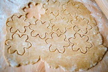 Gingerbread christmas cookies cutters and rolling pin over wooden pastry board