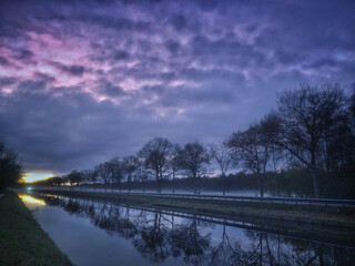 Canal at sunset. Drentse Hoofdvaart Uffelte. Drenthe Netherlands. Trees reflections in the water.