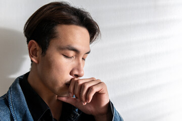 Male depression. Upset Asian young man having problems over white background, having heavy thoughts, break up with lover or financial difficulties Overthinking Unhappy unsatisfied and trouble concept
