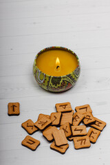 Runes lie next to a burning candle