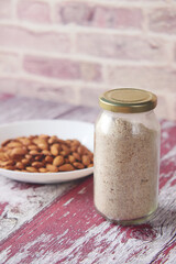 almond powder and almond in a jar on table,